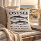 Cozy Coast Kissenhülle OSTSEE 50 x 50 cm in Natur mit dunkelblauen Fischen auf einer Sitzbank am Fenster mit Blick auf Dünen und Ostsee