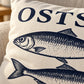 Detailansicht der Cozy Coast Kissenhülle OSTSEE mit dunkelblau gedruckten Fischen auf naturfarbener Baumwolle