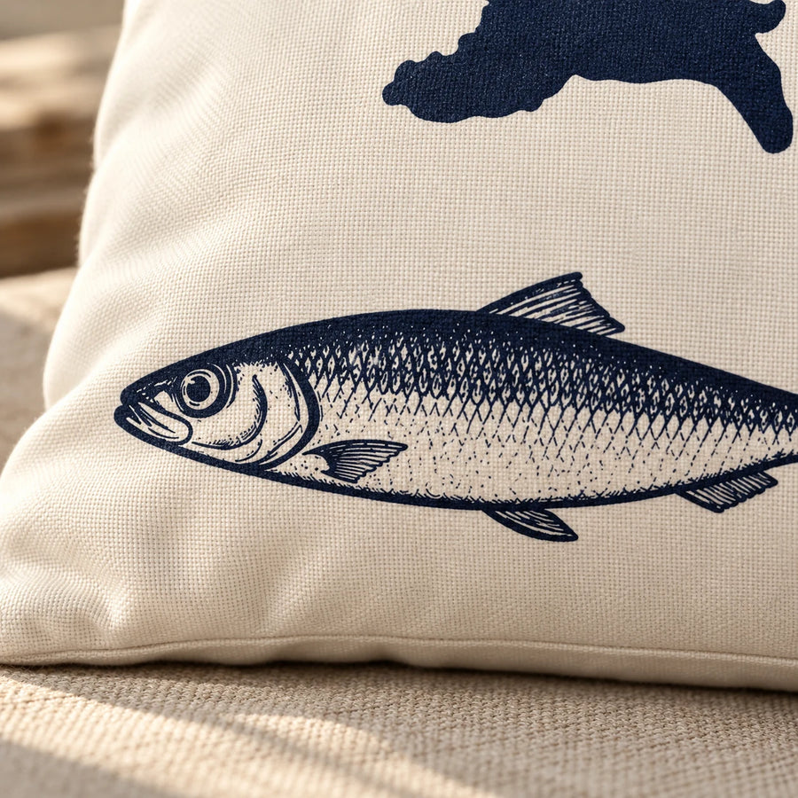 Detailansicht der Cozy Coast Kissenhülle USEDOM mit dunkelblau gedrucktem Fisch und Inselsilhouette auf naturfarbener Baumwolle