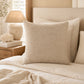 Kissen Riviera Maison Monogram Aveiro Beige auf Bett im Coastal Look