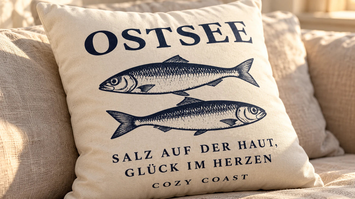 Prall gefüllte Cozy Coast Kissenhülle OSTSEE in Natur mit dunkelblauen Fischen auf einem hellen Leinensofa im warmen Sonnenlicht